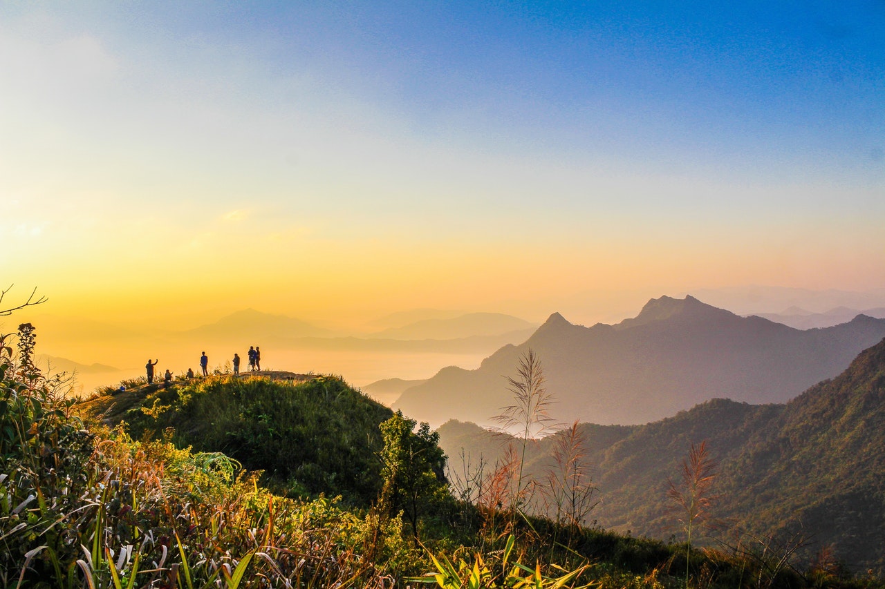 photo-of-people-standing-on-top-of-mountain-near-grasses-733162